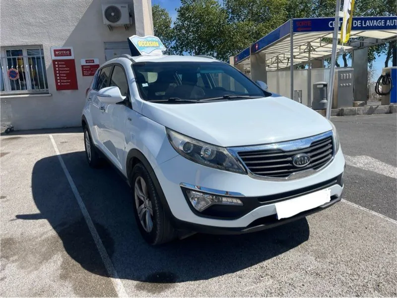 Kia Sportage blanc devant le garage FM Automobiles à Aigues-Vives
